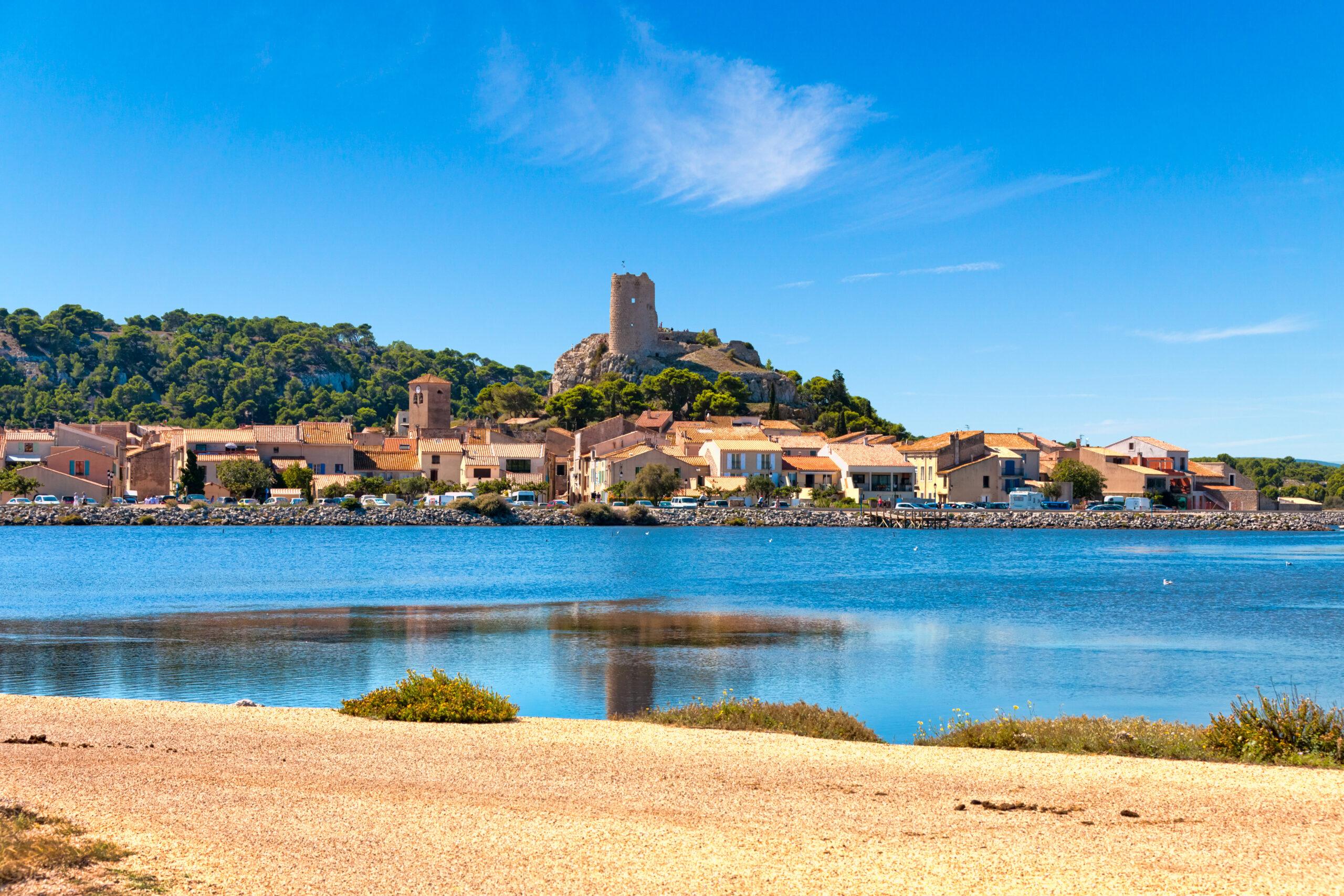view of the village of gruissan with the castle ruins tour barberousse and the pond etang de gruissan in southern france.